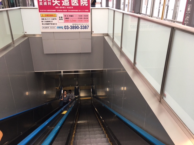 日暮里舎人ライナー西日暮里駅ホームから改札へのエスカレーター下る様子